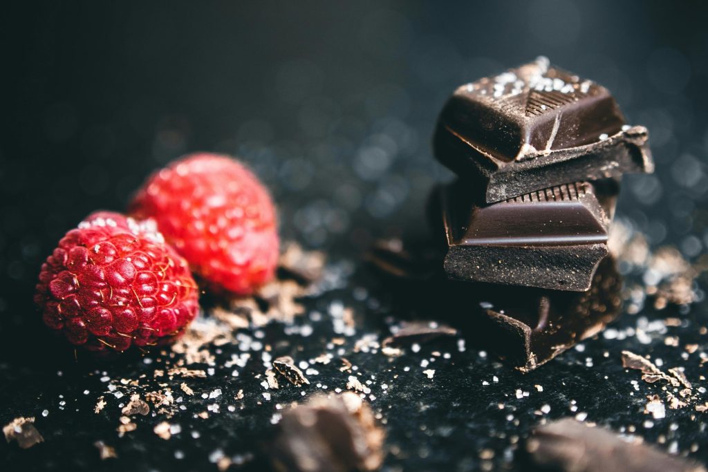 Close-up of dark chocolate pieces and raspberries, perfect for gourmet dessert ideas.